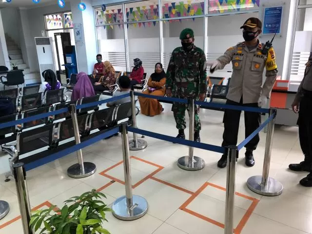 GARIS PEMBATAS : Wakapolres Tanbu, Kompol Arief Prasetia membuat garis pembatas untuk selalu menjaga jarak aman di salah bank di Batulicin.