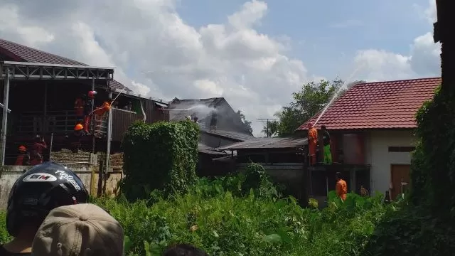 DIPADAMKAN: Para pemadam kebakaran memadamkan api di rumah milik pensiunan PNS di Jalan Penghulu Rasyid, Tanjung.