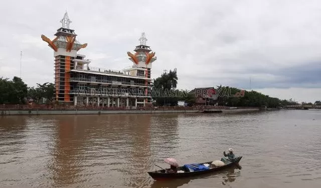 MENARA PANDANG: Perahu melintas di Sungai Martapura, seberang Menara Pandang. Foto diambil dari Siring Sudirman, kemarin (26/6) sore. | FOTO: WAHYU RAMADHAN/RADAR BANJARMASIN