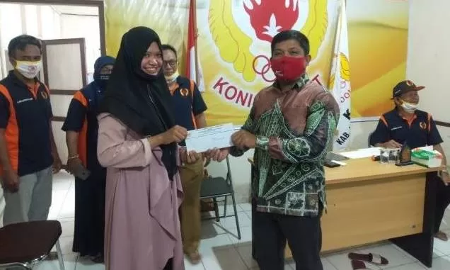 SIMBOLIS: Ketua Umum KONI Kabupaten Hulu Sungai Tengah Yazid Fahmi (kanan) menyerahkan insentif kepada seorang atlet di Kantor KONI HST, Senin (29/6) pagi. | FOTO: JAMALUDDIN/RADAR BANJARMASIN