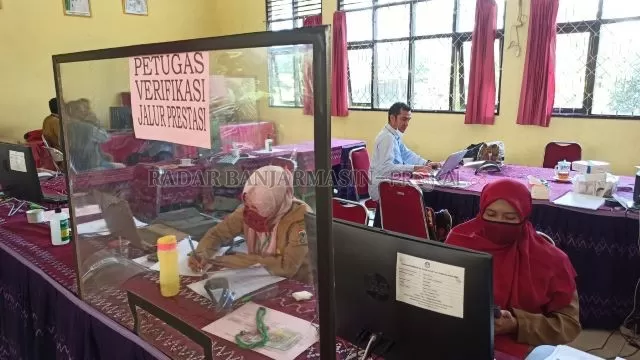 PROTOKOL PANDEMI: Suasana ruangan panitia PPDB online di SMAN 2 Banjarbaru, kemarin. Karena server gangguan, guru tidak bisa memverifikasi berkas pendaftar. | FOTO: SUTRISNO/RADAR BANJARMASIN