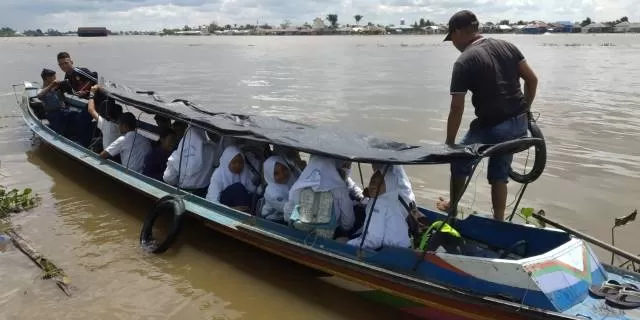KEMBALI KE SEKOLAH: Siswa-siswa di Batola berangkat ke sekolah dengan perahu, tahun lalu. Batola membuka kembali sekolah dengan sejumlah protokol ketat.