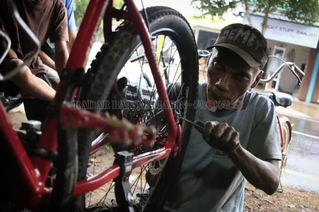 KECIPRATAN TREN: Supar, mekanik di bengkel Sepeda Demet 064 di Jalan Kebun Karet mengerjakan perbaikan salah satu unit sepeda milik konsumennya. Selama tren sepeda ramai, bengkel sepeda di Banjarbaru juga kebanjiran orderan. | FOTO: MUHAMMAD RIFANI/RADAR BANJARMASIN