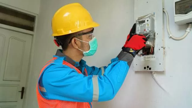 TAMBAH DAYA: Petugas PLN melakukan proses penggantian MCB untuk tambah daya listrik pelanggan. | FOTO: PLN FOR RADAR BANJARMASIN.