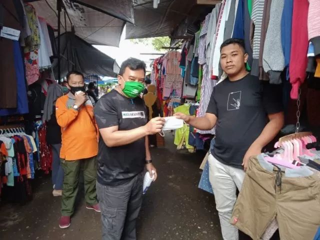BAGIKAN MASKER: Kepala Dinas Komunikasi dan Informatika Ardiansyah (kiri) membagikan masker kepada pedagang di pusat niaga bersujud.