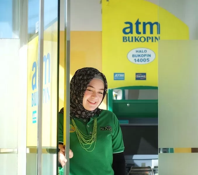 SEMANGAT BARU: Seorang wanita mengambil uang di Anjungan Tunai Mandiri Bukopin. KB kookmin Bank, Bank terbesar asal Korea Selatan resmi menjadi pemegang saham terbesar Bank Bukopin. | DOK/KONTAN