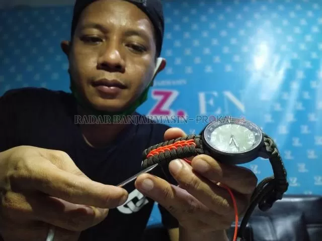 PERAJIN: Surya Tajudin dari Paraborneo menunjukkan keahliannya menganyam tali paracord menjadi strap jam tangan di Kantor Biro Radar Banjarmasin, Senin (3/8) malam. | FOTO: ENDANG SYARIFUDDIN/RADAR BANJARMASIN