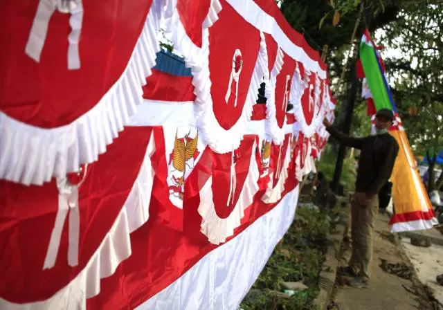 BERBEDA: Salah seorang pedagang bendera merah putih musiman berjualan di kawasan Jln HM Cokrokusomo Banjarbaru. Karena pandemi masih terjadi, Pemko mengambil kebijakan untuk penangguhan kegiatan acara dan lomba 17 Agustus yang bersifat mengumpulkan kerumunan. | Foto: Muhammad Rifani/Radar Banjarmasin