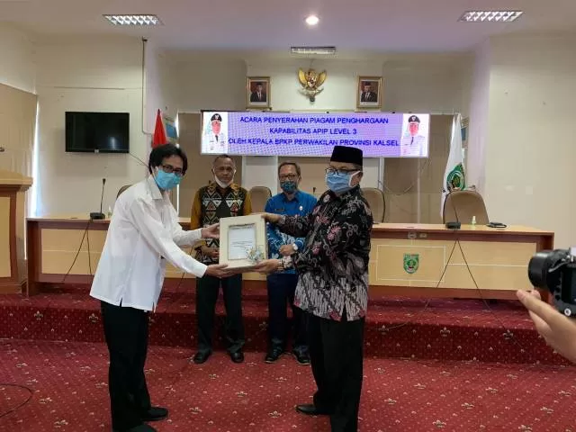 PRESTASI : Bupati Balangan Ansharuddin (kanan) saat menerima piagam penghargaan dari BPKP Provinsi Kalsel. | FOTO: WAHYUDI/RADAR BANJARMASIN