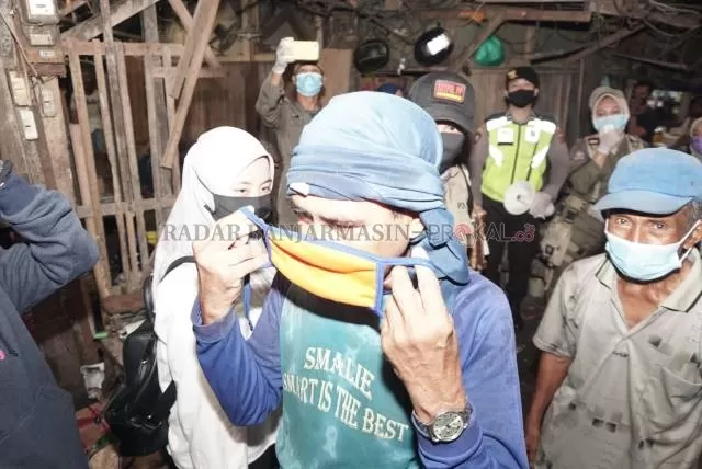 LINDUNGI DIRI: Seorang kuli panggul disuruh mengenakan masker oleh petugas pada penerapan PSBB di Banjarmasin kemarin. | FOTO: WAHYU RAMADHAN/RADAR BANJARMASIN