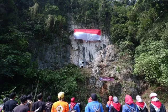 CINTA NEGERI: Bendera merah putih dikibarkan di Tebing setinggi 30 Meter di Tebing Batu Ampik, Desa Gragata, Kecamatan Jaro, Kabupaten Tabalong. | FOTO: IBNU DWI WAHYUDI/RADAR BANJARMASIN