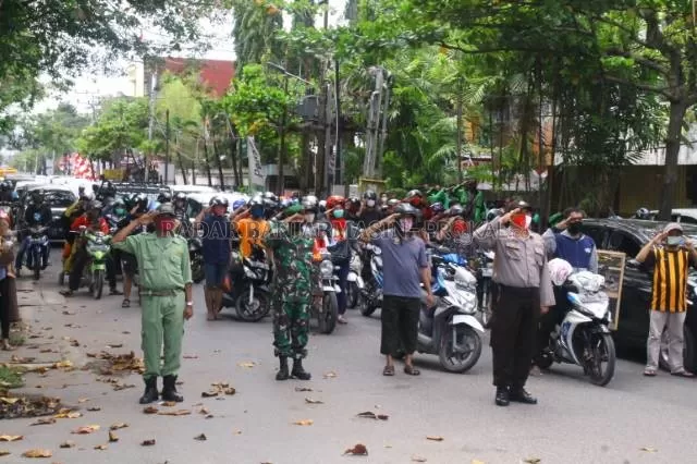 NASIONALISME: Dari anggota TNI, Polri, Linmas, sampai warga dan ojol mengangkat hormat di perempatan Jalan Hasan Basry. Menjelang detik-detik proklamasi sekitar jam 11 siang kemarin. | Foto: Maulana/Radar Banjarmasin