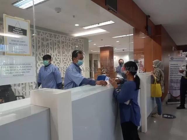 ANTUSIAS: Petugas Bank Indonesia melayani warga Banjarmasin yang meminati uang baru pecahan 75.000. | FOTO: NISA RAUDAH/RADAR BANJARMASIN