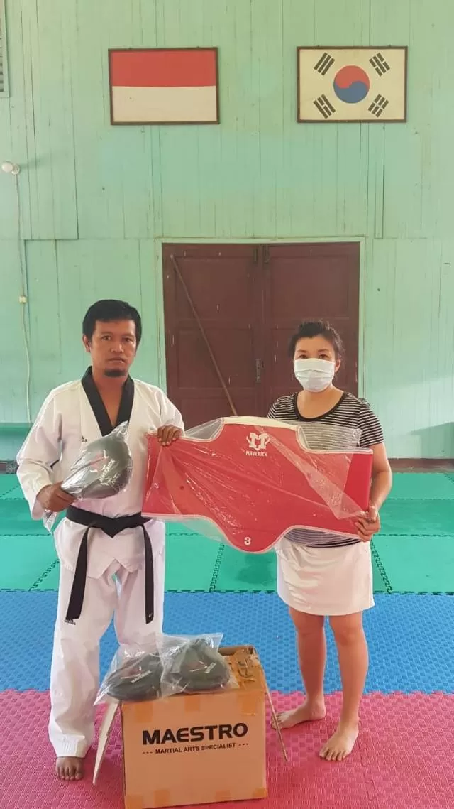 ALAT CANGGIH: Ketua Umum TI Banjarmasin Dewi Purnama Jusup menyerahkan bantuan berupa body protector yang dilengkapi sensor kepada pelatih taekwondo Sabeum Avry Wijaya.