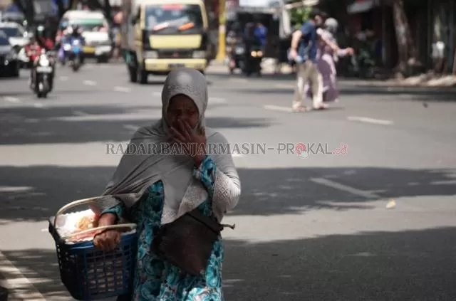 NEKAT: Seorang ibu berjalan di Jalan Hasanuddin HM tanpa mengenakan masker, sepekan lewat. | FOTO: WAHYU RAMADHAN/RADAR BANJARMASIN