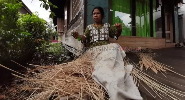 MERAUT LIDI: Marni, junior Swarna, meraut lidi sisa ketupat untuk dijadikan tusuk sate. Dia tinggal di Kampung Kenanga, Sungai Jingah. | FOTO: WAHYU RAMADHAN/RADAR BANJARMASIN
