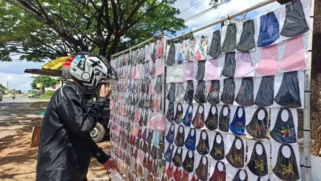 TREN MASKER SCUBA: Seorang pria memilah masker scuba di salah satu lapak di Jalan Trikora, Banjarbaru, kemarin. Masker jenis ini tidak direkomendasikan, karena hanya terdiri dari satu lapis dan terlalu tipis. Sehingga kemungkinan tidak dapat menangkal droplet. | FOTO: SUTRISNO/RADAR BANJARMASIN