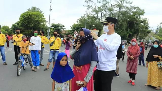 BAGIKAN MASKER: Wakil Wali Kota Banjarbaru H Darmawan Jaya Setiawan bersama Sekretaris Kota Banjarbaru H Said Abdullah saat membagikan masker gratis kepada masyarakat yang berolahraga di Lapangan Murjani, kemarin (20/9). | FOTO: HUMAS DAN PROTOKOL PEMKO BANJARBARU