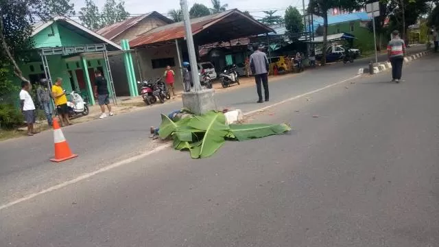 MENINGGAL DUNIA: Korban kecelakaan maut di Jalan Guntung Manggis Landasan Ulin Banjarbaru  pada Minggu (20/9) ditutup daun. | Foto: IST