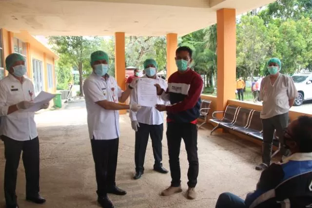 SEMBUH: Wakil Bupati Tala Abdi Rahman menyerahkan surat keterangan sembuh dari Covid -19 usai perawatan di Fasyansus