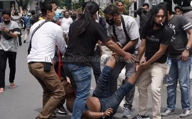 SERIBU DEMONSTRAN: Polisi menyeret penyusup dengan senjata tajam. | Foto: WAHYU RAMADHAN/RADAR BANJARMASIN