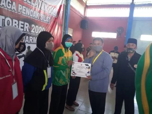 SELAMAT: Kepala Bidang Peningkatan Prestasi Olahraga Dispora Kalsel M Fitri Hernadi menyerahkan medali dan piagam kepada para juara cabor pencak silat Popda Kalsel 2020, Sabtu (17/10).