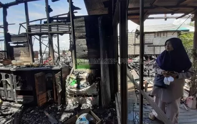 BERSABAR: Seorang ibu menengok rumahnya yang habis terbakar. Pemko harus memikirkan keberadaan armada BPK di Pulau Bromo sebagai antisipasi. | FOTO: WAHYU RAMADHAN/RADAR BANAJRMASIN