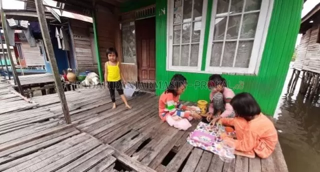BERMAIN DI TERAS: Anak-anak di Pulau Bromo bermain tanpa mengenakan masker. Berbulan-bulan menghadapi pandemi, kian banyak warga Banjarmasin yang cuek. | FOTO: WAHYU RAMADHAN/RADAR BANJARMASIN
