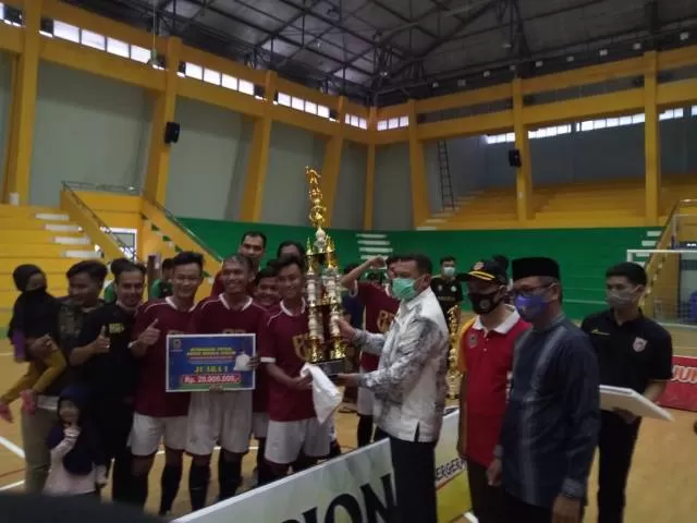 KAMPIUN: Kadispora Kalsel Hermansyah menyerahkan trofi juara kepada tim futsal Remaja Masjid Al Misbah Banjarmasin di GOR Hasanudin HM Banjarmasin, Jumat (23/10).