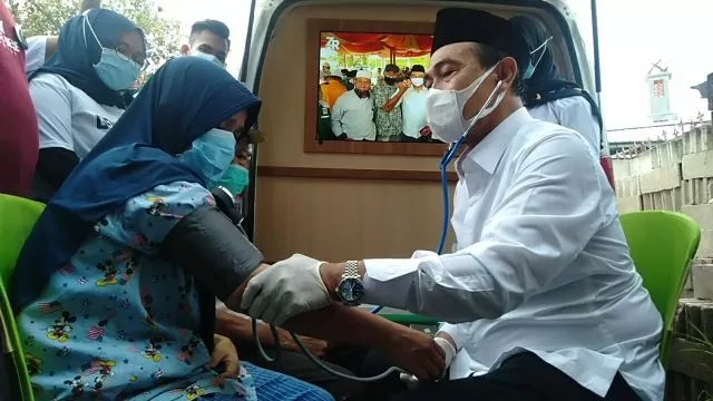 SENANG : Rustinah (45) merasa sangat senang karena dirinya langsung diperiksa kesehatannya oleh dr H M Zairullah Azhar di Desa Pasar Baru Kecamatan Kusan Hilir.