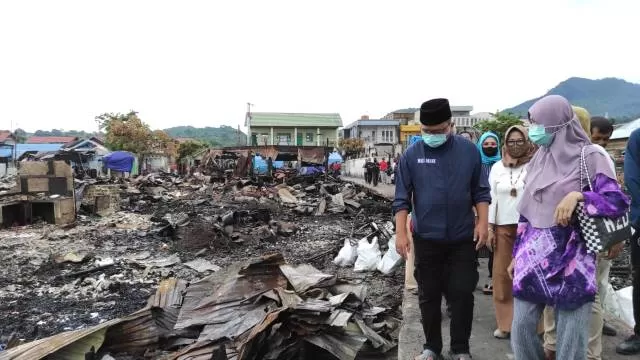 LIHAT LOKASI LOKASI KEBAKARAN: Haji Denny ditemani beberapa relawan Kotabaru berjalan di antara puing-puing sisa kebakaran hebat di kawasan Patmaraga Kotabaru, Senin (2/11) sore.