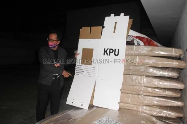 LOGISTIK: Ketua KPU HST Johransyah menunjukkan kotak suara Pilkada 2020. Kotak ini akan dirakit untuk dilihat, apakah ada yang rusak atau cacat. | Foto JAMALUDDIN/Radar Banjarmasin