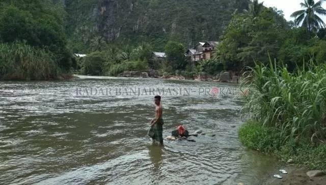 BERNILAI: Seorang warga mandi di sungai di Desa Batu Tangga Kecamatan Batang Alai Timur yang dipagari pegunungan Meratus. Peneliti menemukan bebatuan langka di Meratus. | Foto: DOK/RADAR BANJARMASIN