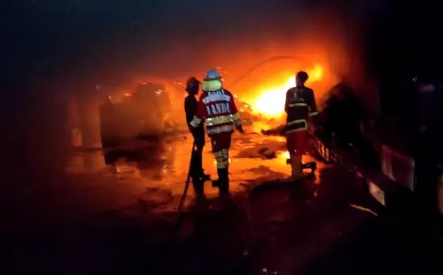MEMBARA: Petugas pemadam kebakaran gabungan berusaha memadamkan api yang melalap gudang penyimpanan herbisida di Liang Anggang pada Selasa (10/11) malam. | Foto: ISTIMEWA