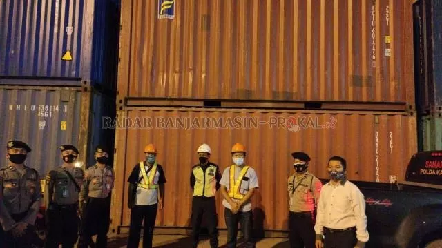 JAGA KETAT: Para petugas berjaga di depan kontainer surat suara yang dikirim dari Surabaya di Pelabuhan Trisakti Banjarmasin, Senin (16/11) malam. | FOTO: M OSCAR FRABY/RADAR BANJARMASIN