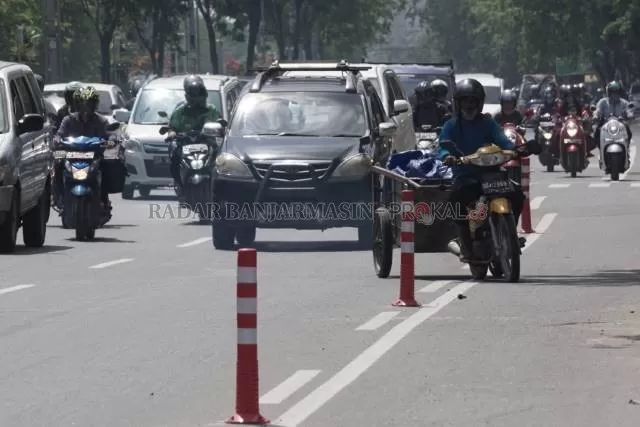 SEROBOT: Pengendara yang menarik gerobak ini menerobos jalur pesepeda di Jalan Ahmad Yani kilometer 4, Selasa (17/11) pagi. | FOTO: WAHYU RAMADHAN/RADAR BANJARMASIN
