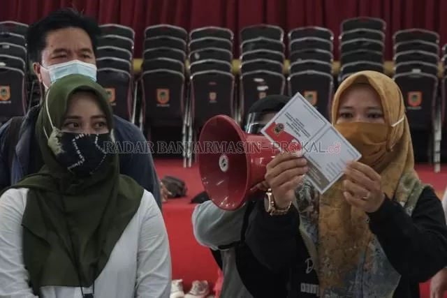 SURAT SUARA: Komisioner KPU mempraktikkan cara melipat surat suara Pilgub Kalsel, Jumat (20/11) di Gedung Wanita Kayu Tangi. | FOTO: WAHYU RAMADHAN/RADAR BANJARMASIN