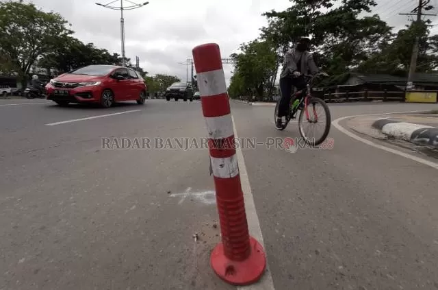 MAU COPOT: Stick cone untuk menandai jalur gowes ini rusak karena terlalu sering ditabrak pengguna kendaraan bermotor. Foto diambil di Jalan Ahmad Yani kilometer 5, kemarin (23/11). | FOTO: WAHYU RAMADHAN/RADAR BANJARMASIN