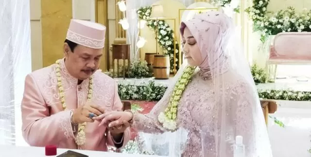 Plt Gubernur Kalsel Rudy Resnawan saat menyematkan cincin ke jari Risnia Puspitasari, dalam pernikahan mereka di Grand Dafam Q Hotel Banjarbaru, Kamis (26/11) malam. | FOTO: ISTIMEWA