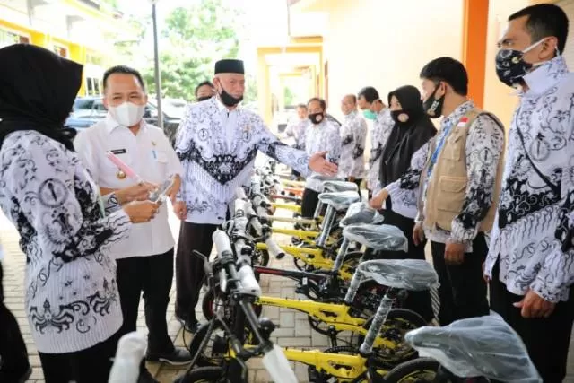 SERAHKAN HADIAH: Bupati Tanbu H Sudian Noor menyerahkan hadiah sepeda kepada 20 guru berprestasi.