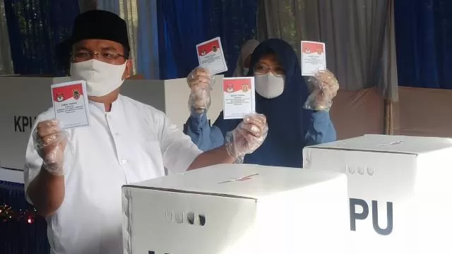 Calon Gubernur Kalsel nomor urut 2, Denny Indrayana bersama istri saat memperlihatkan surat suara yang sudah dicoblosnya, Rabu (9/12) pagi. | FOTO: SUTRISNO