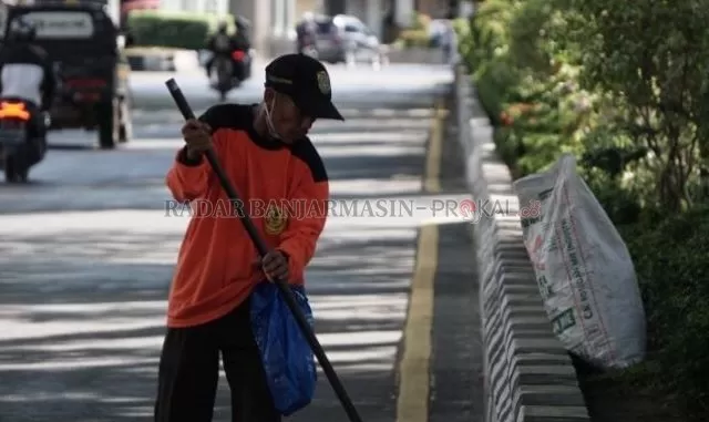 PASUKAN KUNING: Inilah petugas kebersihan yang resmi dari Dinas Lingkungan Hidup Banjarmasin. Foto diambil di Jalan Lambung Mangkurat, kemarin. | FOTO: WAHYU RAMADHAN/RADAR BANJARMASIN