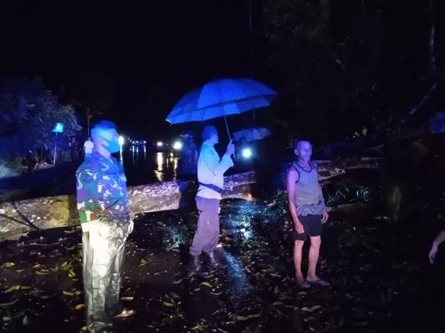 EVAKUASI: Tim BPBD HST, TNI-Polri bersama warga berjibaku mengevakuasi pohon asam yang tumbang menghalangi jalan di Desa Kapar-Kapur Jawa RT 10, Batang Alai Selatan, Sabtu (12/12) malam. | Foto: Istimewa