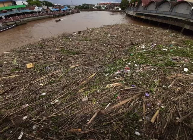 TERTUTUP SAMPAH: Sungai Martapura, sungai terbesar yang membelah Kota Banjarmasin tertutupi ratusan ton sampah. Foto diambil kemarin (28/12) dari atas Jembatan Antasari. | FOTO: WAHYU RAMADHAN/RADAR BANJARMASIN