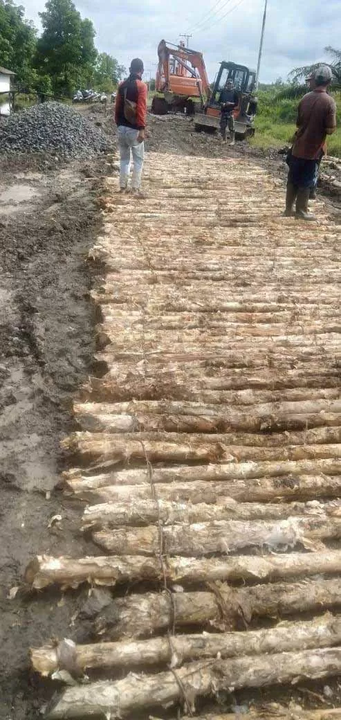 TAK MUDAH: Perbaikan ruas jalan rusak dengan pondasi kayu galam dan batu, yang dianyam dengan besi di kawasan Desa Balukung.