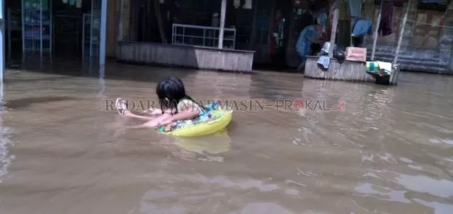 BERTAHAN: Sebagian besar korban banjir di Teluk Selong Martapura memilih bertahan di rumah kendati debit air terus meningkat dan diprediksi lama baru surut. | FOTO: M AMIN/RADAR BANJARMASIN
