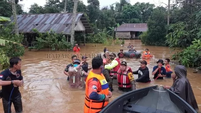 EVAKUASI: Evakuasi seorang nenek korban banjir di Kelurahan Bangkal, Kecamatan Cempaka. Petugas juga mengevakuasi barang-barang elektronik dari sebuah sekolah yang terendam. | FOTO: RIFANI/RADAR BANJARMASIN