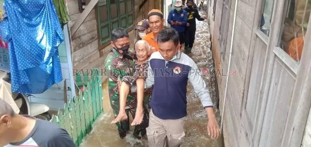 EVAKUASI: Petugas mengevakuasi seorang lansia dari banjir di Kecamatan Pengaron. Banjir tahun ini
 meluas karena hujan yang terus turun membuat sungai-sungai kecil meluap. | FOTO: MUHAMMAD AMIN/RADAR BANJARMASIN