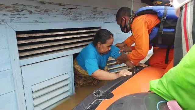 LEWAT JENDELA: Anggota Basarnas Banjarmasin saat mengevakuasi korban banjir di Desa Teluk Selong, Kabupaten Banjar, kemarin. | FOTO: BASARNAS BANJARMASIN FOR RADAR BANJARMASIN