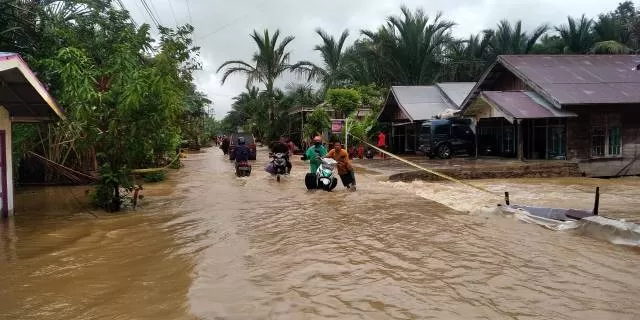 TERENDAM: Jalan Jermani Husin Desa Kalintamui Kecamatan Banjang menuju Kecamatan Lampihong Kabupaten Balangan telah terdampak luapan sungai Balangan, Jumat (15/1).